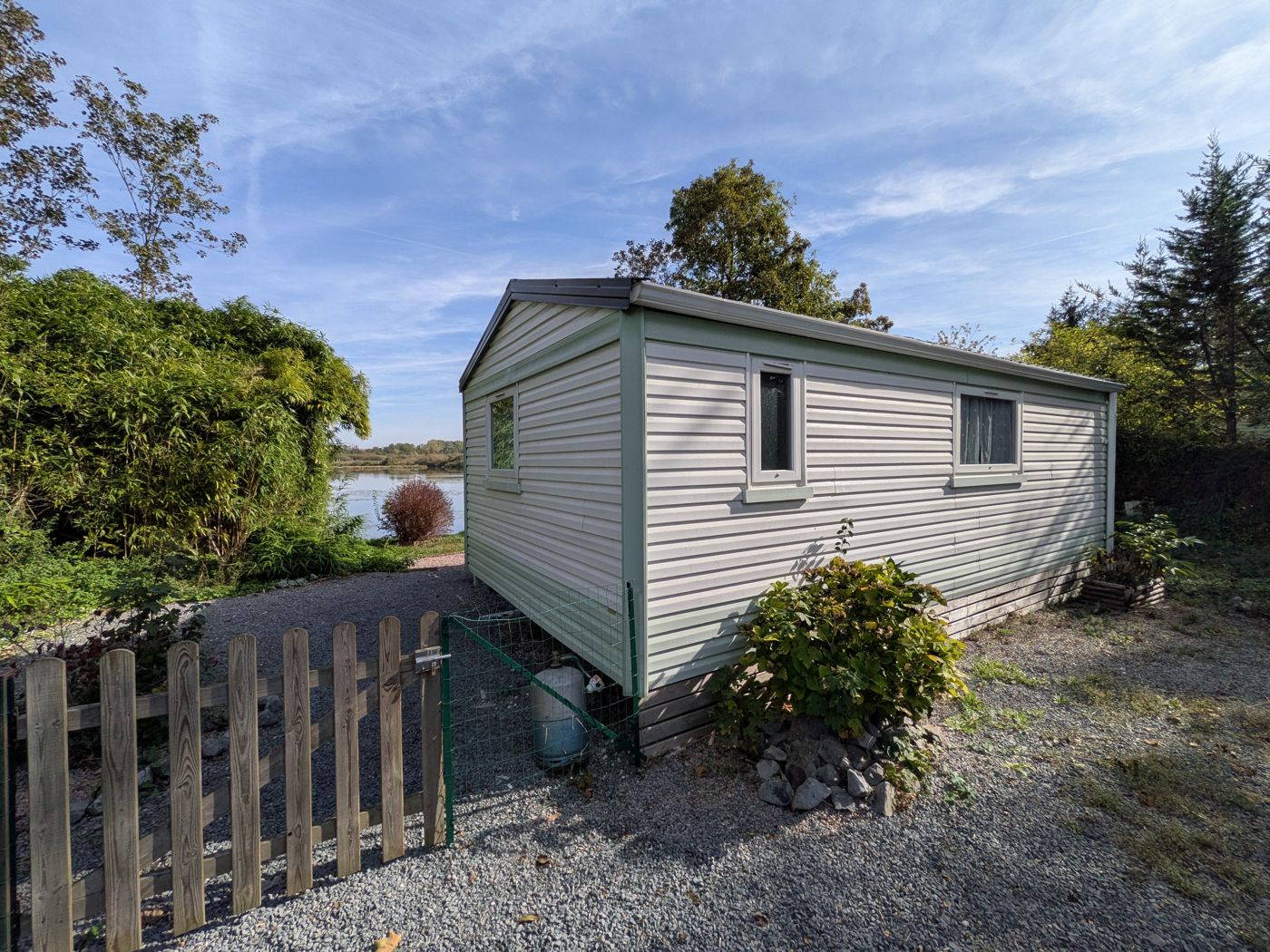 Mobile home on its enclosed pitch by the pond