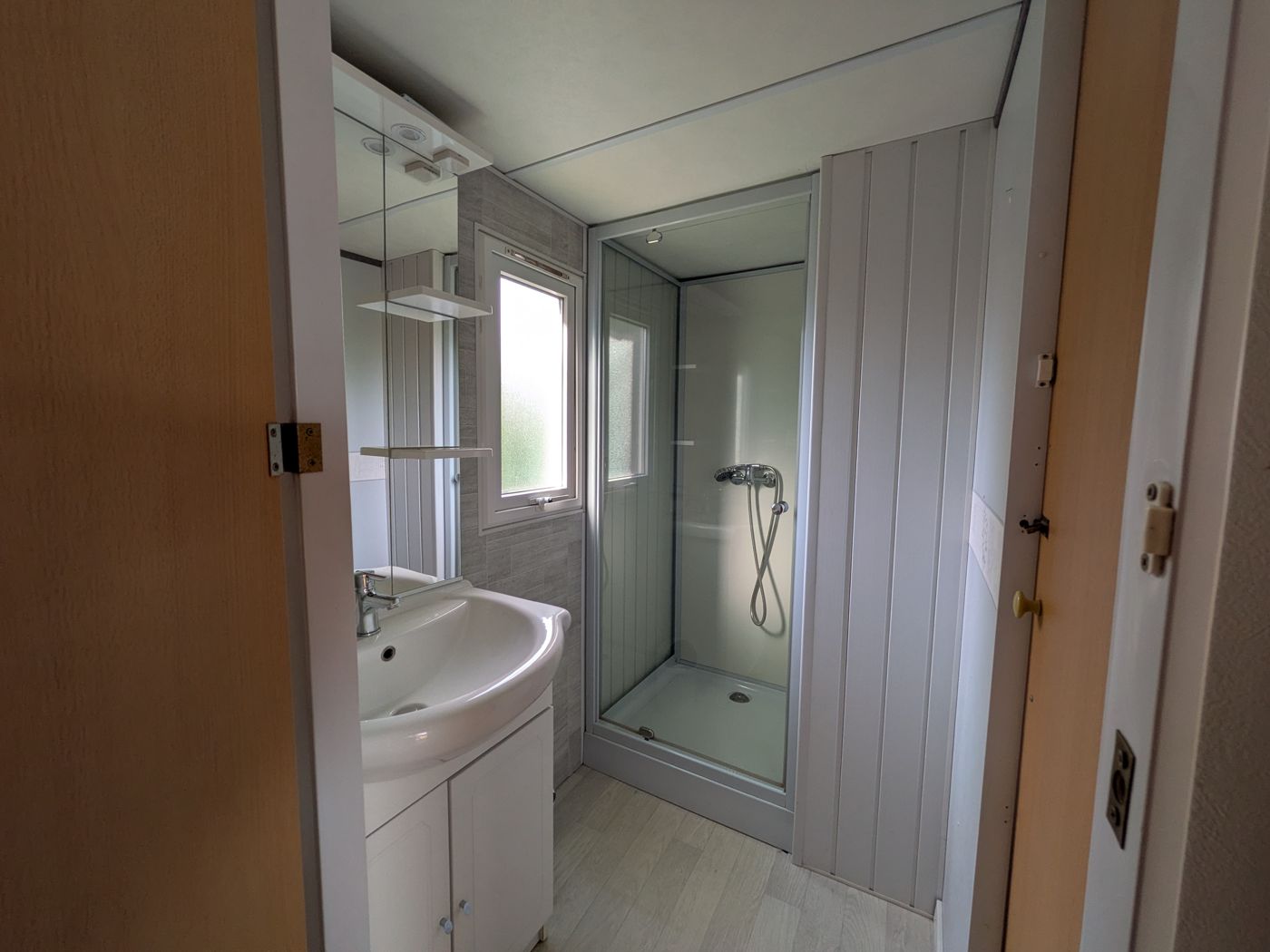 Badkamer met douche en wastafel