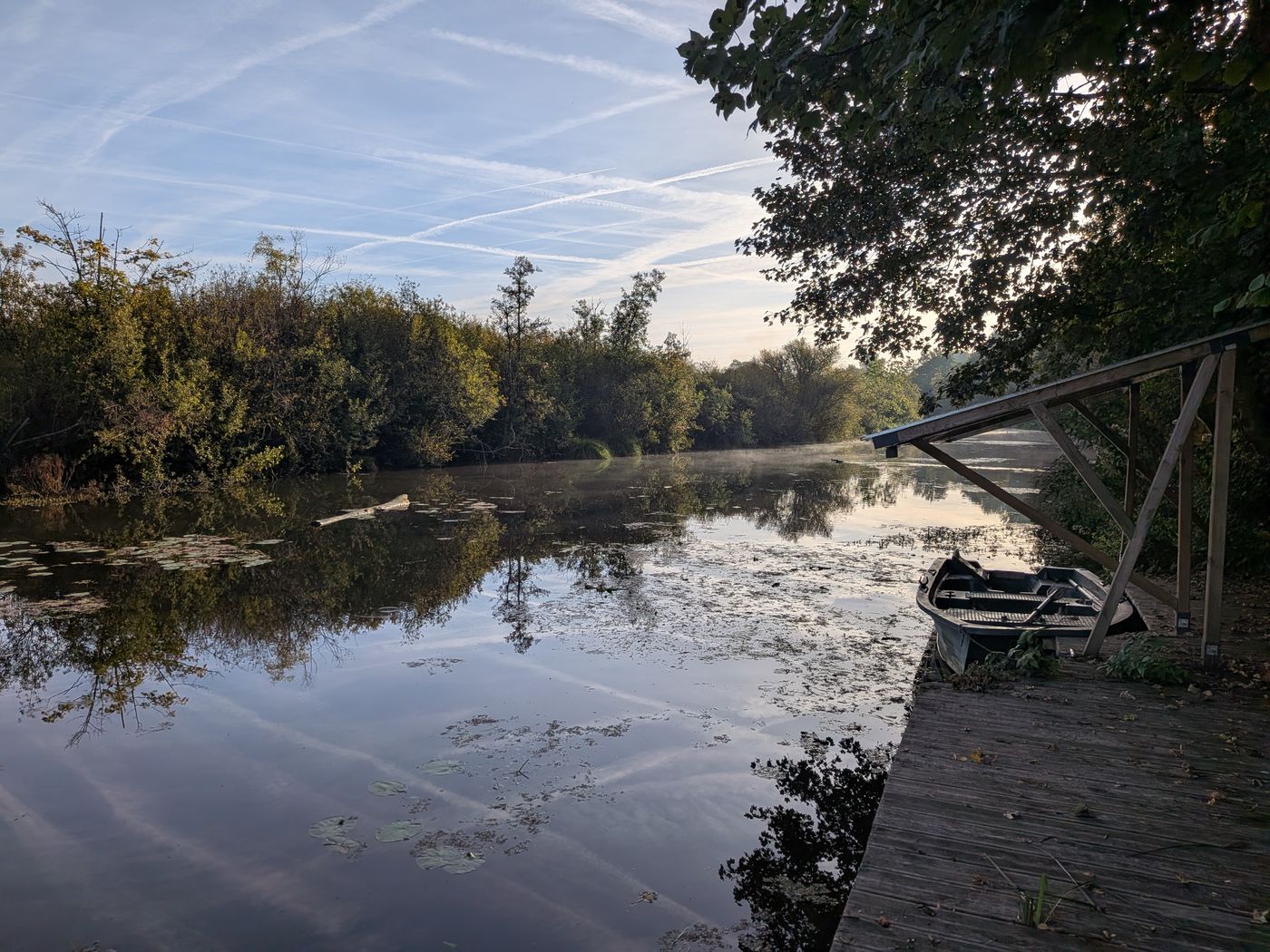 Jetty and boat on the pond at dawn
